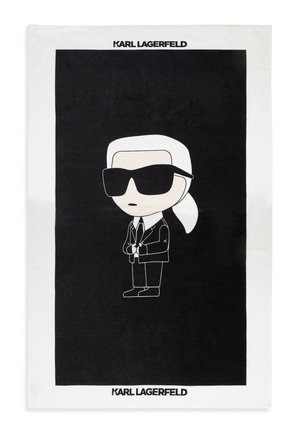 Kreslená postava s bielymi vlasmi v chvoste, čiernymi slnečnými okuliarmi, čiernym oblekom a kravatou, umiestnená v strede na čiernom pozadí s textom "KARL LAGERFELD" hore a dole.