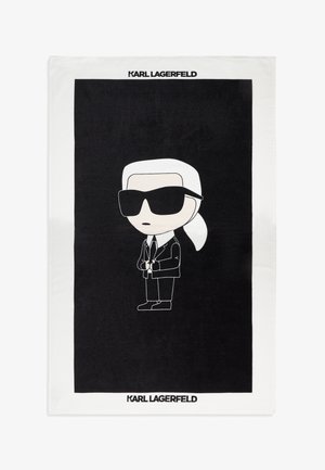Figure de dessin animé aux cheveux blancs en queue de cheval, lunettes de soleil noires, costume noir et cravate centrée sur un fond noir avec le texte "KARL LAGERFELD" en haut et en bas.