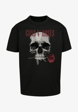 Černé bavlněné tričko s šedou kostlivcem a červenou růží, nad designem je nápis "GUNS N' ROSES" v červené barvě. Krátké rukávy.