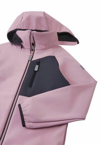 Jasnoróżowa kurtka softshell z czarnym akcentem na ramieniu, z przodu na zamek i z kieszenią na zamku na klatce piersiowej. Posiada kaptur i elastyczne mankiety.