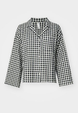 Camicia a maniche lunghe a quadri bianco e nero con colletto, orlo dritto, realizzata in tessuto leggero.