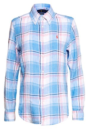 Chemise à manches longues boutonnée avec motif à carreaux bleu, blanc et rouge et petit logo rouge brodé sur la poitrine.