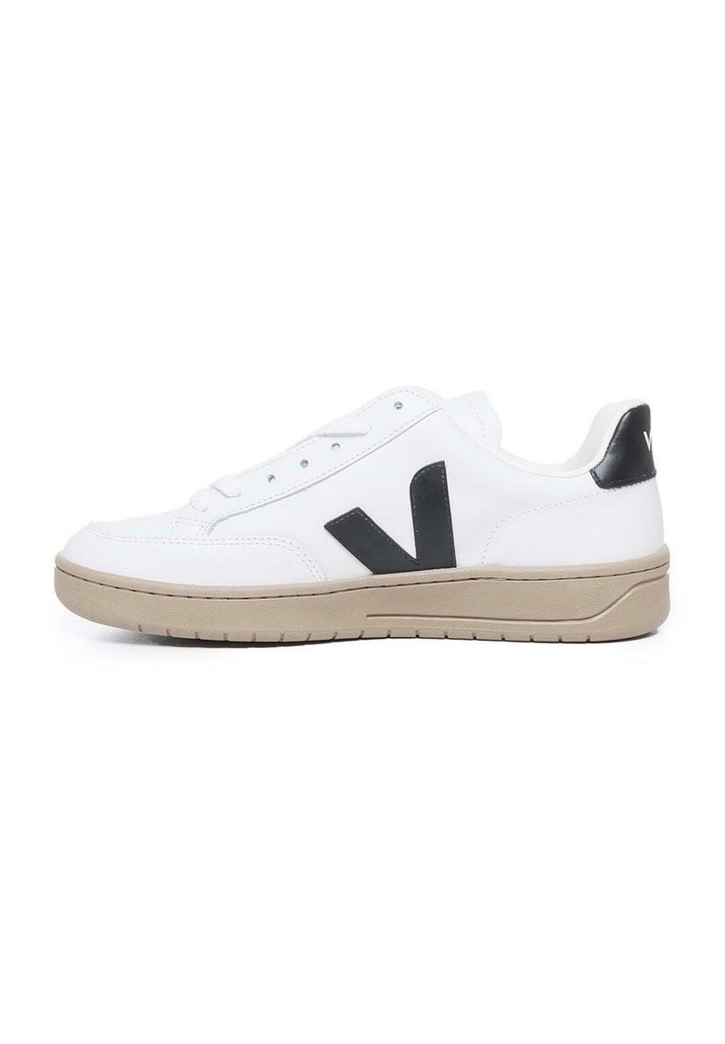 White leather sneaker with a black "V" logo, beige rubber sole, and flat laces. Features smooth texture and cushioned collar.