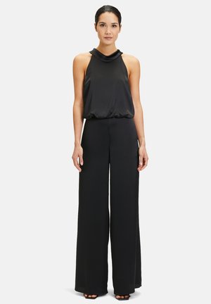Black jumpsuit with a halter neck design, flowing top section, and wide-leg pants. Smooth fabric with a relaxed fit and minimal detailing.