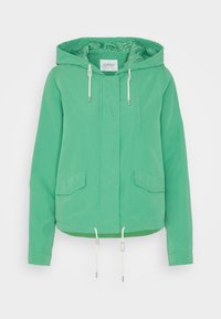 Zielona kurtka z kapturem, wykonana z lekkiego materiału. Posiada elastyczne sznurki, dwie przednie kieszenie oraz krótki krój o gładkiej fakturze.