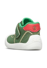 Sneaker verde in rete con suola in gomma bianca; presenta una fascia in Velcro e un accento in pelle rossa sul tallone. Design testurizzato e dettagli di cucitura.