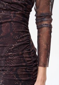 Sukienka marszczona w brązowo-czarny wzór wężowy, z przezroczystymi rękawami z siateczki i fakturowaną tkaniną o dopasowanym kroju.