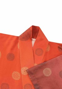 Red kimono with a deep neckline featuring large, circular gold and black patterns. The fabric appears smooth with a subtle sheen.