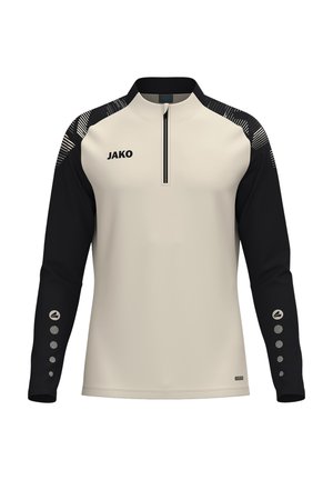 Langarmig sportshirt met beige voorkant en zwarte mouwen, ritssluiting kraag, patroonaccenten op de schouders, JAKO-logo op de borst en knoopachtige ontwerpen op de mouwen.