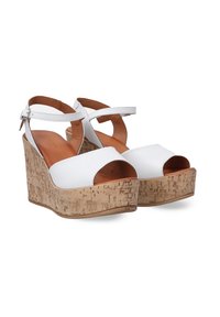 Sandales à talons compensés blanches avec bout ouvert, plateforme en texture liège et brides de cheville réglables. Tige en cuir lisse et semelle intérieure beige.