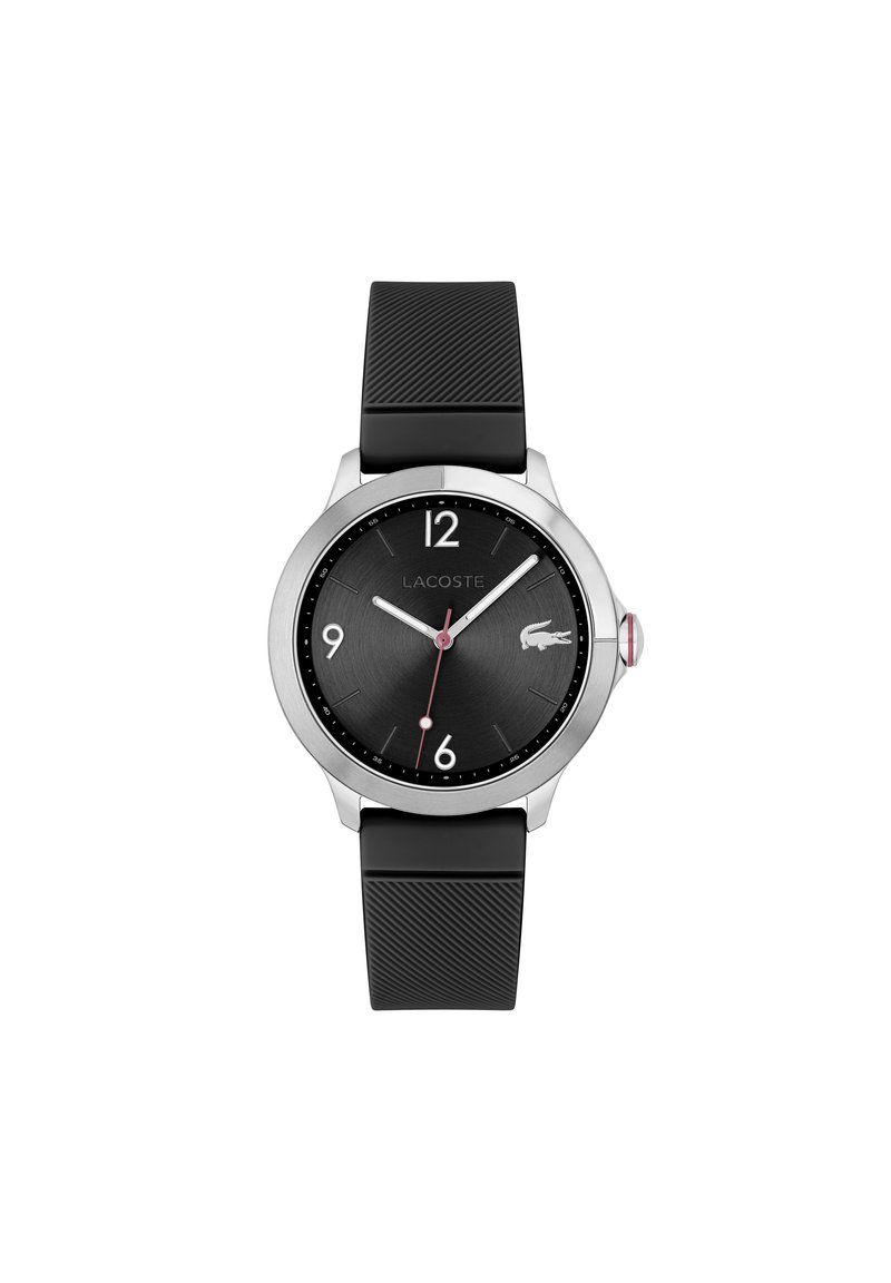 Montre Lacoste noire avec un boîtier rond en argent, un bracelet en silicone noir texturé et un cadran sombre avec des index horaires blancs et une aiguille des secondes rouge.