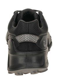Black athletic shoe with a textured mesh upper and rubber sole. Features a reflective heel accent and cushioned interior for comfort.