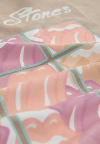 Produkt tekstylny prezentujący wielokolorowy, abstrakcyjny wzór w pastelowych odcieniach różu, brzoskwini i bieli na teksturowanej tkaninie.