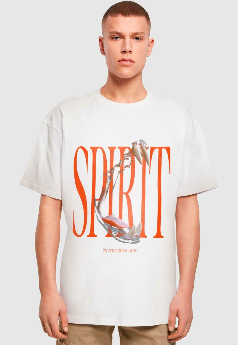 Fehér pamut póló élénk narancssárga "SPIRIT" grafikával, amely halakat és vizet ábrázol. Kerek nyakkivágású, laza szabású.