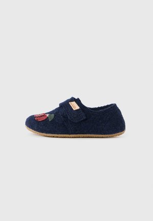 Zapatilla de felpa en color azul marino con una correa de gancho y bucle, que presenta un diseño floral bordado en rojo y verde, y una suela de goma texturizada en tono marrón.