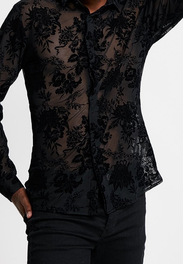 Camicia nera trasparente con bottoni, caratterizzata da ricami floreali in un motivo testurizzato, maniche lunghe e colletto classico.
