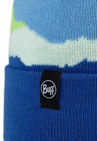 Knitted beanie in blue, featuring a textured pattern with light green and white waves. Black "Buff" logo tag visible on the cuff.
