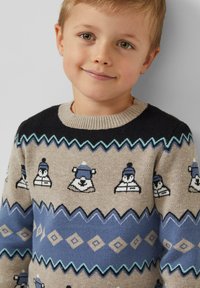 Sweter dziergany z beżowym korpusem i czarnymi rękawami, z niebiesko-białymi zwierzęcymi wzorami oraz prążkowanym, okrągłym dekoltem. Teksturowana, przytulna tkanina.