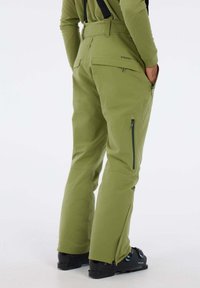 Groene skibroek met verstelbare banden, zijzakken en ritssluitingen bij de enkels. Gemaakt van duurzaam, soepel materiaal.