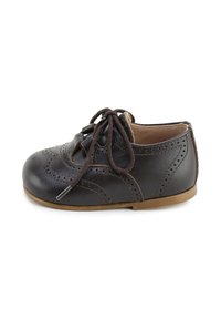Zapato de cuero marrón con puntera redondeada, perforaciones decorativas y cordones marrones. Presenta una suela de goma color beige y un forro interior suave.