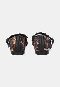 Bailarinas con estampado de leopardo y detalles en cuero negro, punta redonda y un bajo tacón negro. Material suave con textura y un detalle atado en la parte posterior.