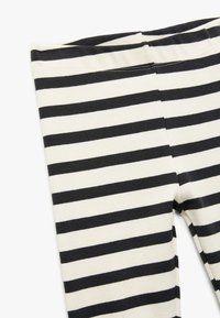 Svart- och vitt randiga leggings med ribbad textur, som har en åtsittande design och ett elastiskt midjeband för komfort.