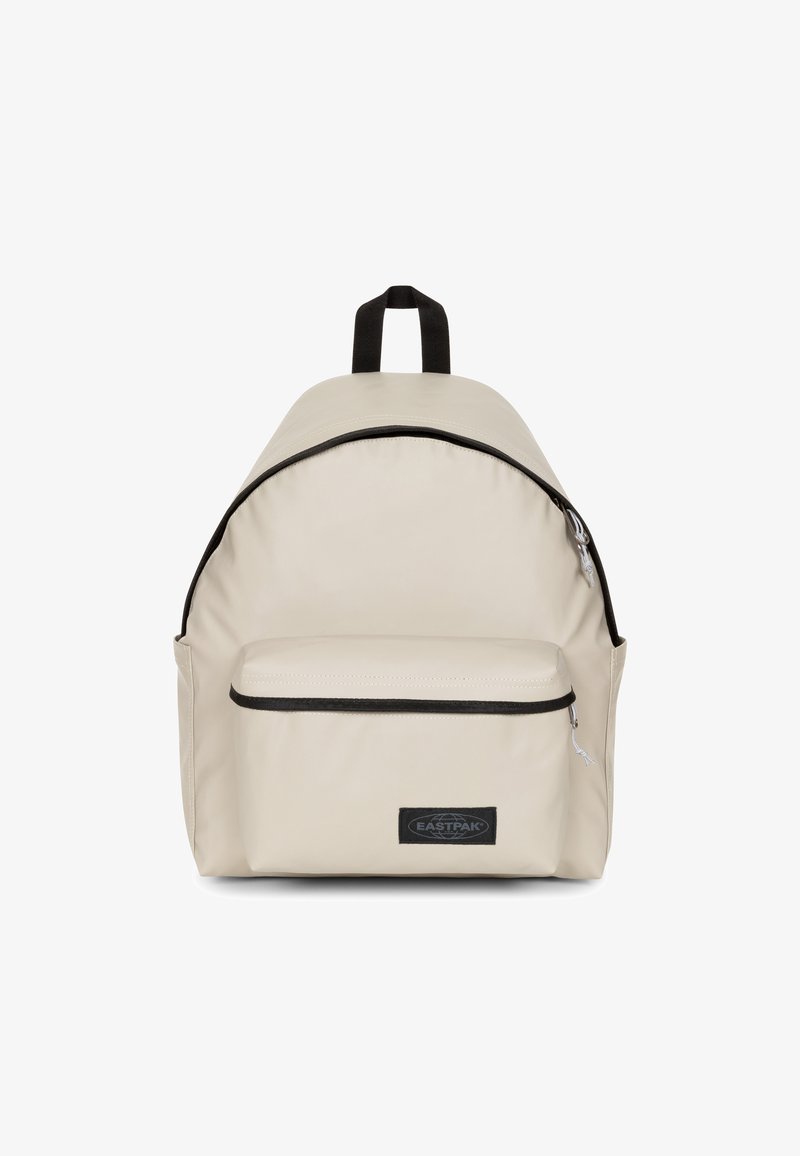 Zaino in nylon beige con parte superiore arrotondata, tasca frontale con zip e dettagli neri. Dotato di manici doppi per il trasporto e spallacci regolabili.