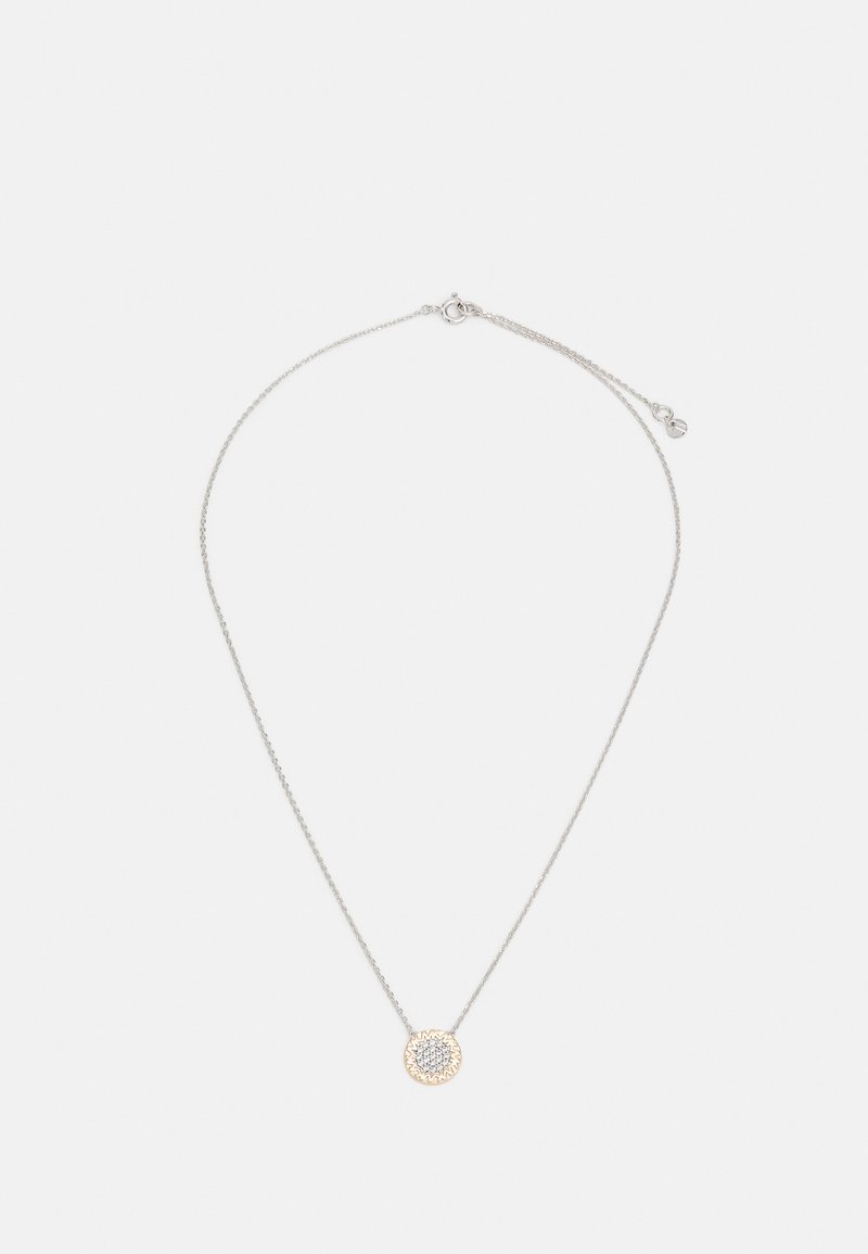 Collier délicat en chaîne d'argent avec un petit pendentif rond doté d'un motif soleil texturé au centre.