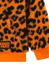 Fuzzy orange sweater with black leopard print. Features knitted cuffs and hem. Kenzo Paris label in black with orange text at the bottom.