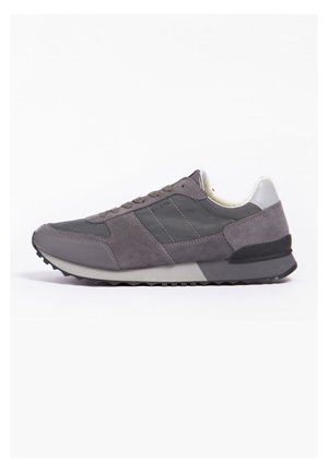 Scarpa sportiva grigia con una combinazione di materiali scamosciati e sintetici, suola in gomma testurizzata e un branding sottile sul lato.