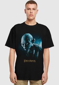 Svart bomull T-skjorte med Gollum fra "Ringenes Herre" i blå og grå design, med logotext nederst.