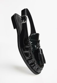 Schwarzer Lackleder Slingback-Schuh mit flachem Absatz, gefalteter Gestaltung und dekorativen Quasten. Verfügt über einen mit Schnalle verstellbaren Knöchelriemen für einen sicheren Sitz.
