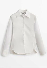 Chemise blanche à manches longues avec col pointu, présentant un devant boutonné, une texture lisse et un ourlet incurvé avec des fentes latérales.