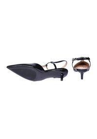 Tacchi slingback in vernice nera con punta affusolata e tacco kitten basso. Presentano una cinghia alla caviglia e una suola testurizzata.