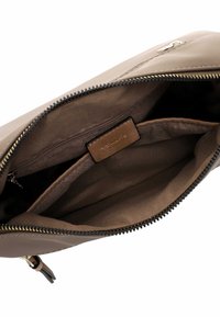 Borsa in pelle marrone con chiusura a zip, caratterizzata da una superficie liscia, una foderatura interna e un piccolo scomparto con etichetta.