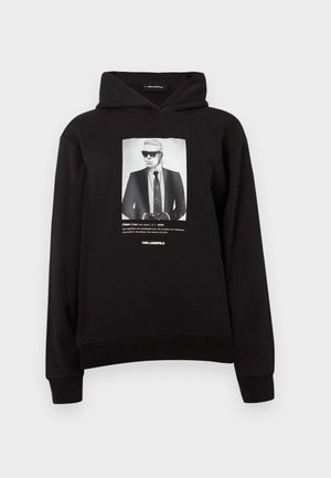 Black hoodie featuring a front print of a figure in sunglasses, wearing a suit and tie. Ribbed cuffs and hem provide a fitted look.
