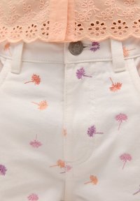 Witte denim shorts met meerkleurige geborduurde paardenbloemmotieven in oranje en paars, voorzien van een metalen knoop en voorzakken.