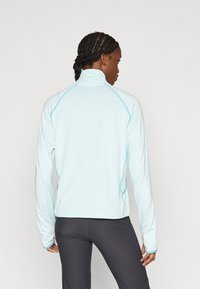 Ανοιχτό μπλε, μακρυμάνικο πουλόβερ με ψεύτικο γιακά και αντίθετη ραφή. Υφή υφάσματος, εφαρμοστό σχέδιο, κατάλληλο για αθλητική χρήση.