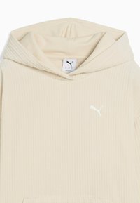 Beige hættetrøje med ribbet tekstur, kengurulomme og hvid Puma-logo på brystet. Blødt stof med en afslappet pasform.