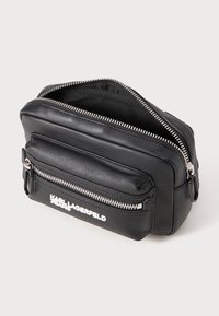 Borsa rettangolare nera in pelle con due scomparti con zip e logo bianco. Superficie testurizzata e dettagli in metallo argentato.