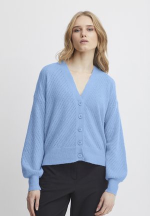 Vaaleansininen neulecardigan, jossa on V-pääntie, kuuden nappulan kiinnitys, vinosti neulottu ribbikuvio ja pallo-olkakappaleet ribbiohjeilla.