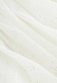 Witte tule stof met een zachte textuur, voorzien van verspreide gouden glitterdeeltjes, wat een lichte en luchtige uitstraling creëert.