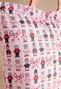 Borsa rosa con un motivo di cani cartoon in vari outfit e fiocchi a pois, realizzata in materiale morbido con spallacci.