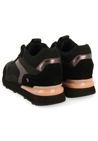 Zapatillas deportivas negras con materiales de malla y nobuk. Presentan detalles metálicos y una suela acolchada de color rosa claro. Diseño de perfil bajo.