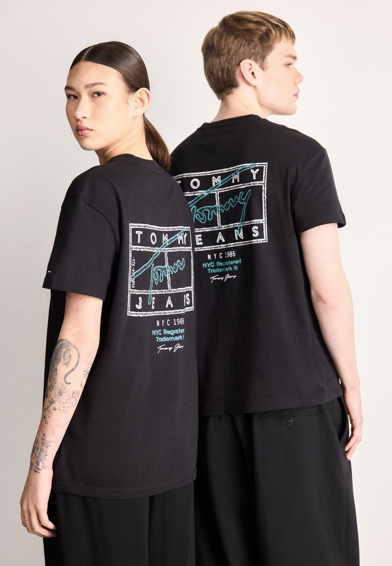 Czarne bawełniane koszulki z grafiką z logo "TOMMY JEANS" i turkusowymi akcentami. Krótkie rękawy i luźny krój. Prosty okrągły dekolt.