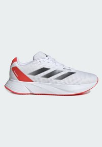 Zapatilla deportiva blanca con parte superior de malla, tres rayas negras, cuello acolchado y un acento rojo en el talón y la suela. Diseño ligero.