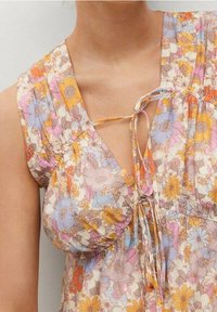 Robe florale avec une palette de couleurs pastel comprenant des fleurs oranges, roses et bleues. Décolleté en V avec un détail à nouer et des manches courtes froncées.