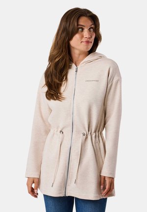 Beige hooded zip-up jacket with drawstring waist and long sleeves. Features a subtle texture and a small logo on the left chest.