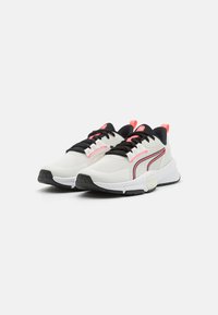 Zapatillas deportivas blancas con acentos en negro y rosa, que presentan una parte superior de malla transpirable, un collar acolchado y una suela de goma texturizada.