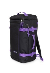 Zaino nero con dettagli viola. Presenta spallacci regolabili, cerniere e un tessuto spesso e morbido. Forma squadrata con molteplici scomparti.